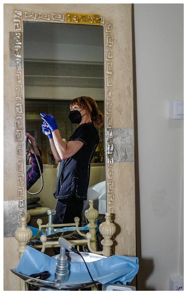 Profesional médico reflejada en un espejo mientras trabaja